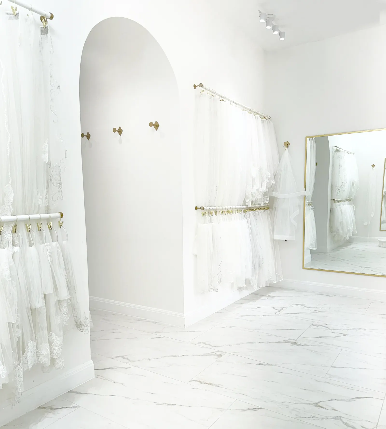 wedding dresses and bridal gowns in a white hallway